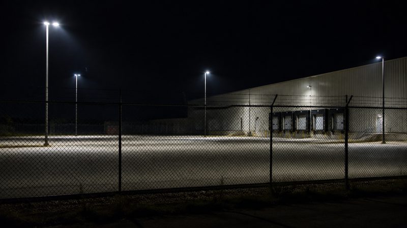 A commercial warehouse yard with perimeter lighting at night